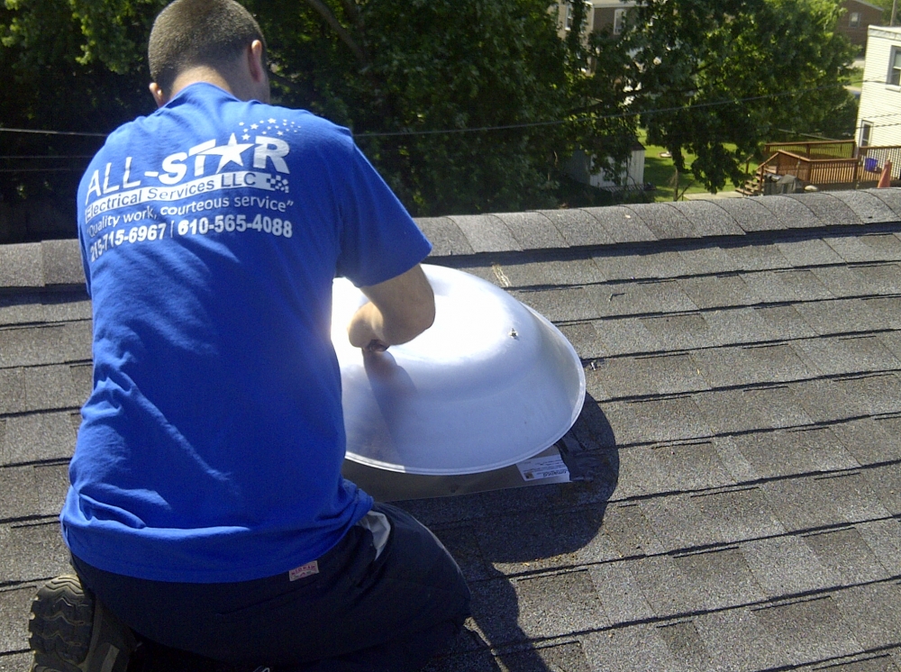 A technician from All Star Electrical Services, LLC working on a roof