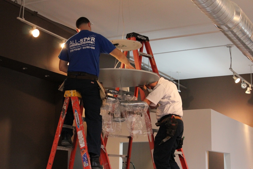Two men installing a lighting fixture