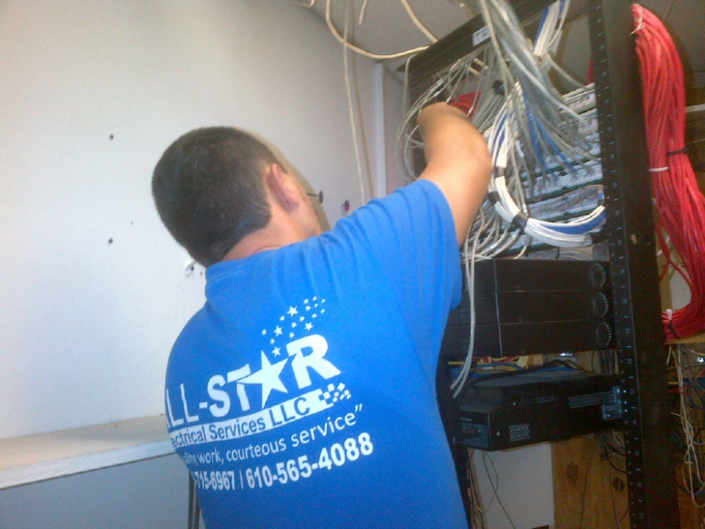 A technician from All Star Electrical Services, LLC working on an electrical panel