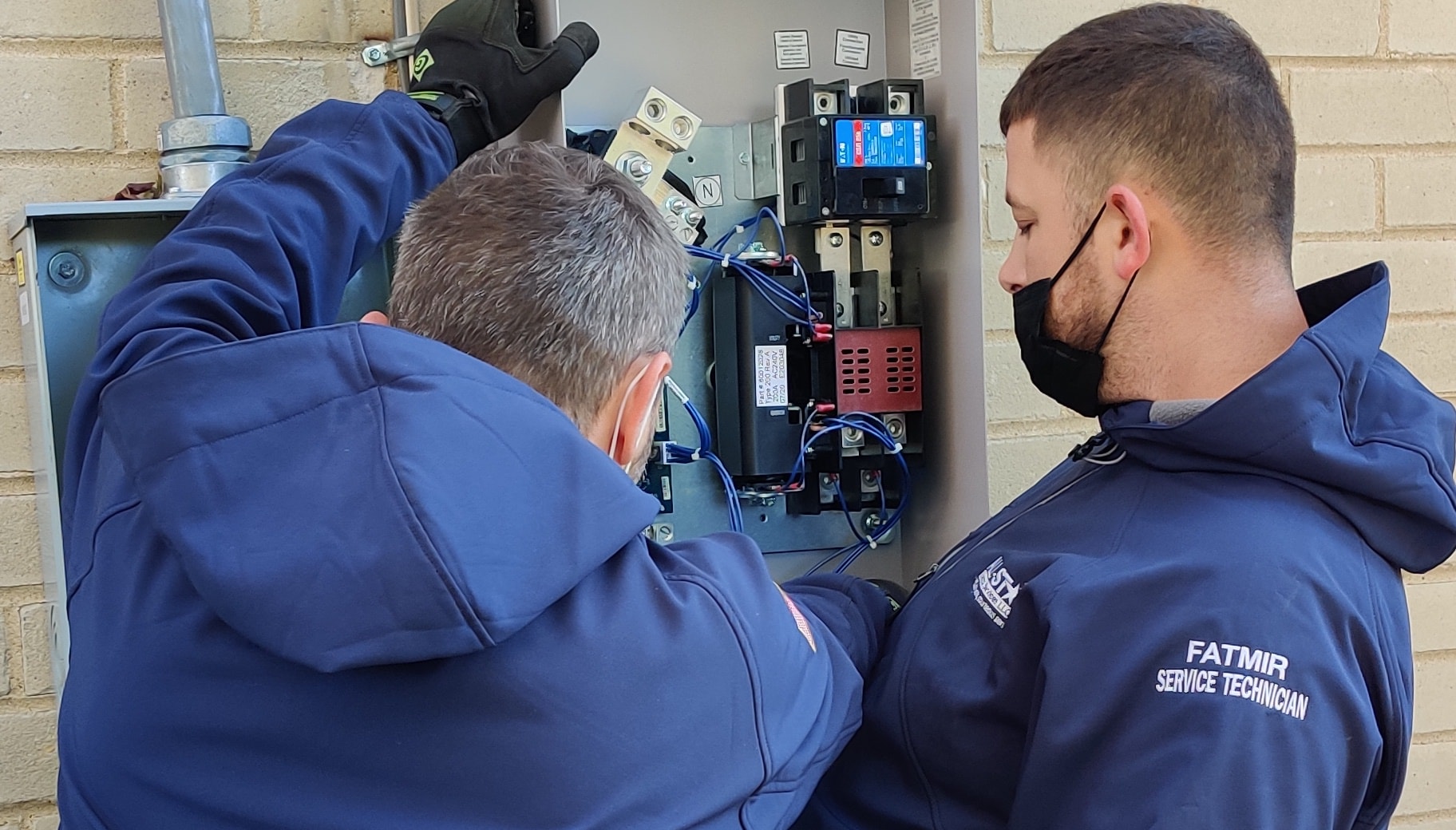 Two technicians from All Star Electrical Services, LLC working on an electrical panel