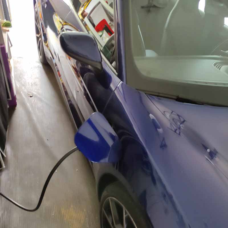 Close up on an EV's charging port, plugged in